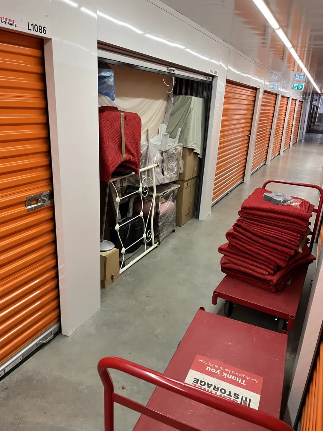 Protected belongings and red moving blankets at a storage facility