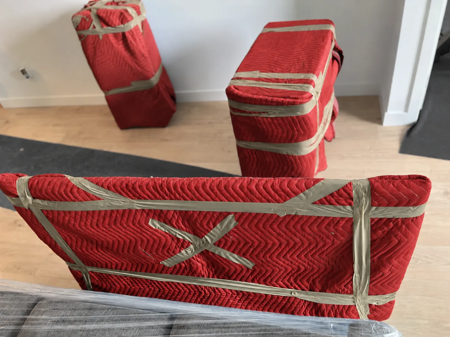 Furniture protected in red quilted moving blankets